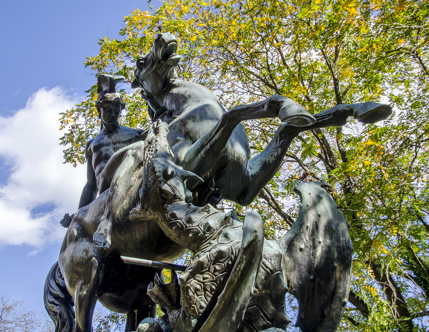 St George and the Dragon bronze sculpture in West Fairmount Park, surrounded by trees and sky
