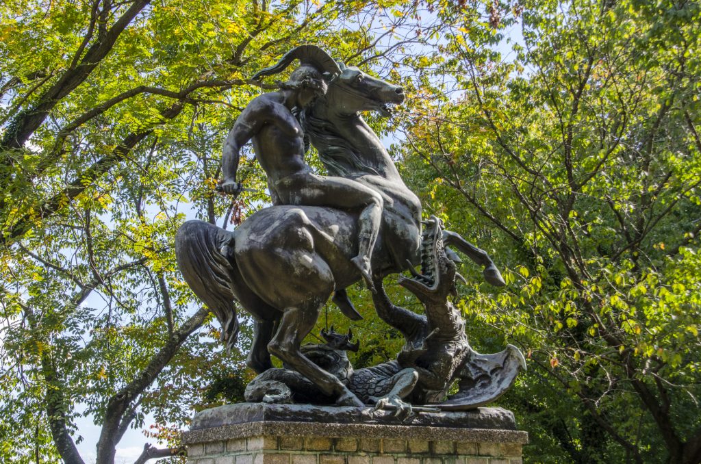 St George and the Dragon bronze sculpture in West Fairmount Park, surrounded by trees and sky